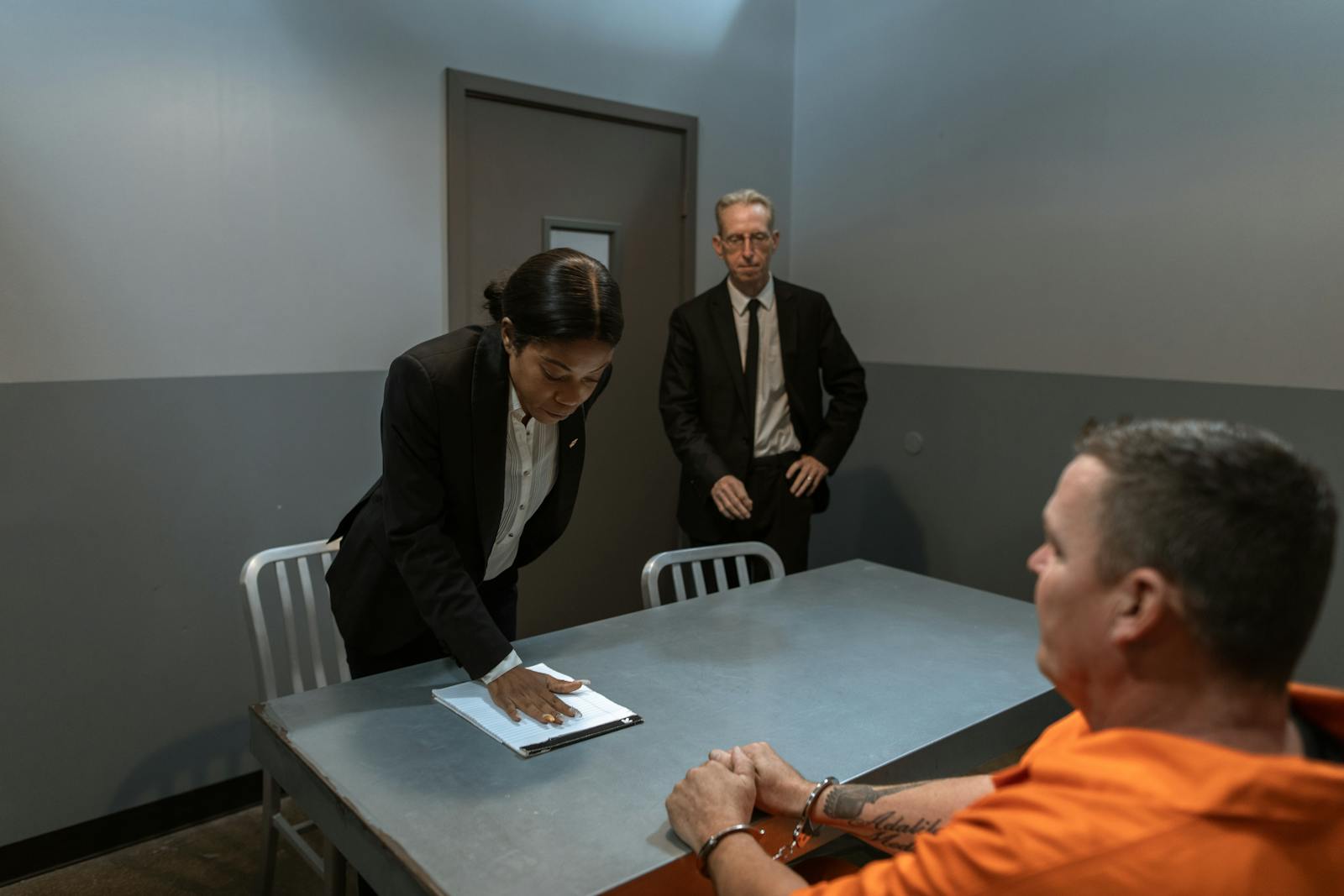 Man in Black Suit Jacket Standing Beside Man in Orange Jacket